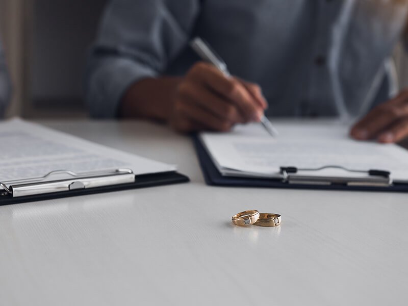 Husband and wife crate signing divorce documents at lawyer office